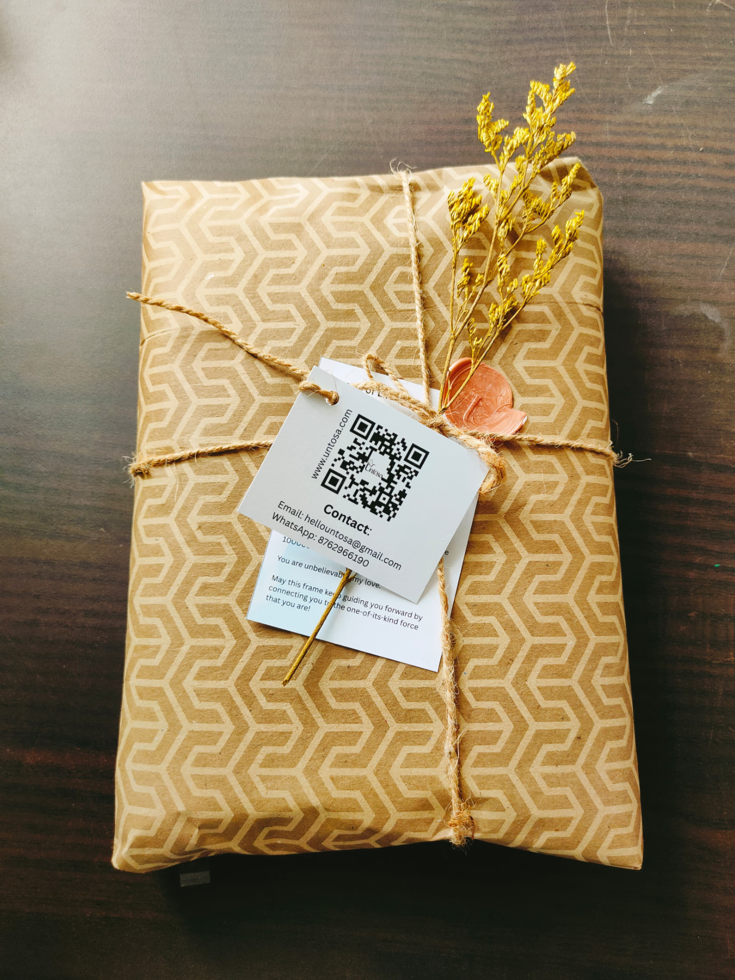 Patterned kraft parcel tied with twine, wax seal and a tagged note card